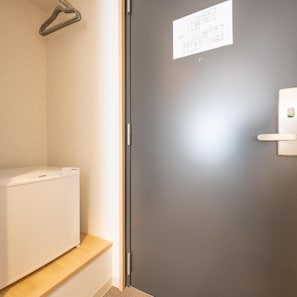 A room with a white appliance, a grey door, and a small wooden shelf. - Fuji Hotel Kyoto Gojo (Kyoto)