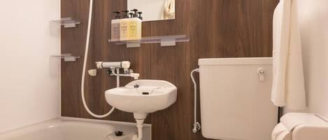 A modern bathroom with a bathtub, sink, toilet, and wooden wall paneling.