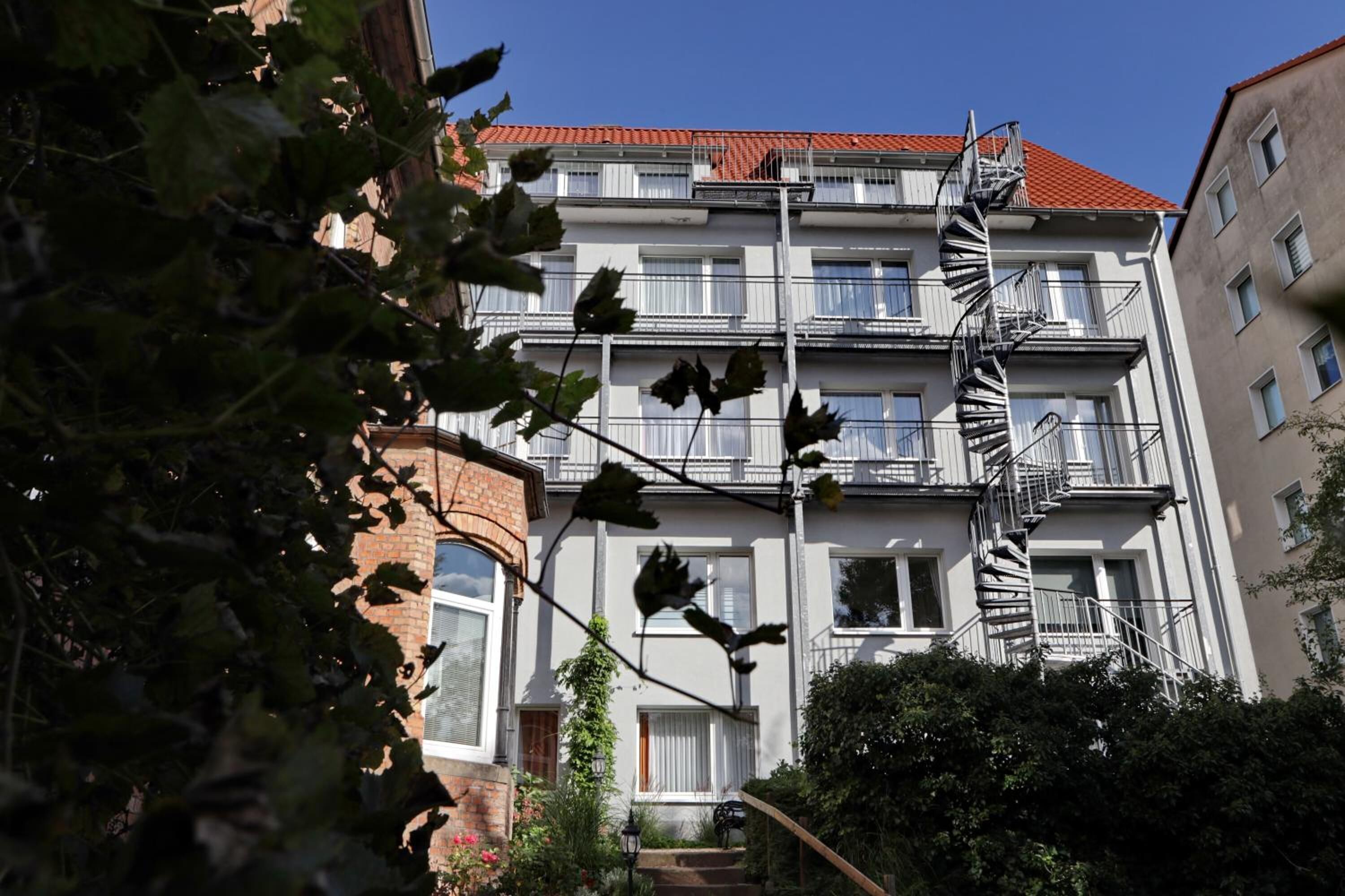 A multi-story building with a spiral staircase, brick facade, and multiple balconies.