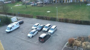 Un estacionamiento con varios coches y una camioneta blanca.