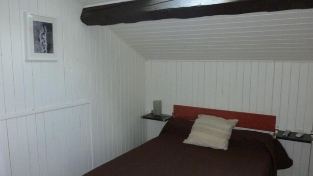 A small, single-bed room with white paneled walls and a dark wooden ceiling beam. - Hotel de L'avenue (Bonson)