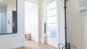 A spacious room with a wooden floor, a large mirror, and a coat rack. - Apparthotel T3 Epicservices Saint-charles (Marseille)