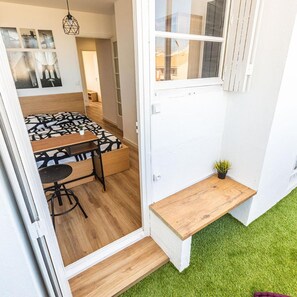 Um espaço compacto com cama, uma mesinha e um banco.