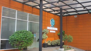 An urban hotel with a modern facade, large windows, and potted plants. - Urban Hotel Serpong by Zuzu (South Tangerang)