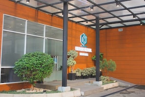 An urban hotel with a modern facade, large windows, and potted plants. - Urban Hotel Serpong by Zuzu (South Tangerang)
