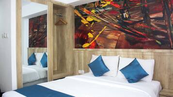 Ein Hotelzimmer mit einem großen Bett, einem Spiegel und einem farbenfrohen abstrakten Gemälde an der Wand.