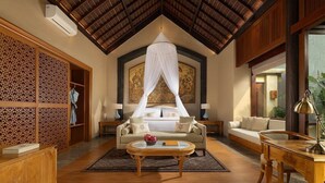 A spacious room with a high ceiling, a bed with a canopy, a sofa, a coffee table, and a desk with a lamp. - Abisena Wellness & Resort Ubud-adult Only (Tegallalang)
