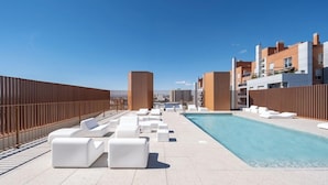A rooftop pool area with white lounge chairs and a swimming pool. - Loop Homes Tower Burjassot (Burjasot)