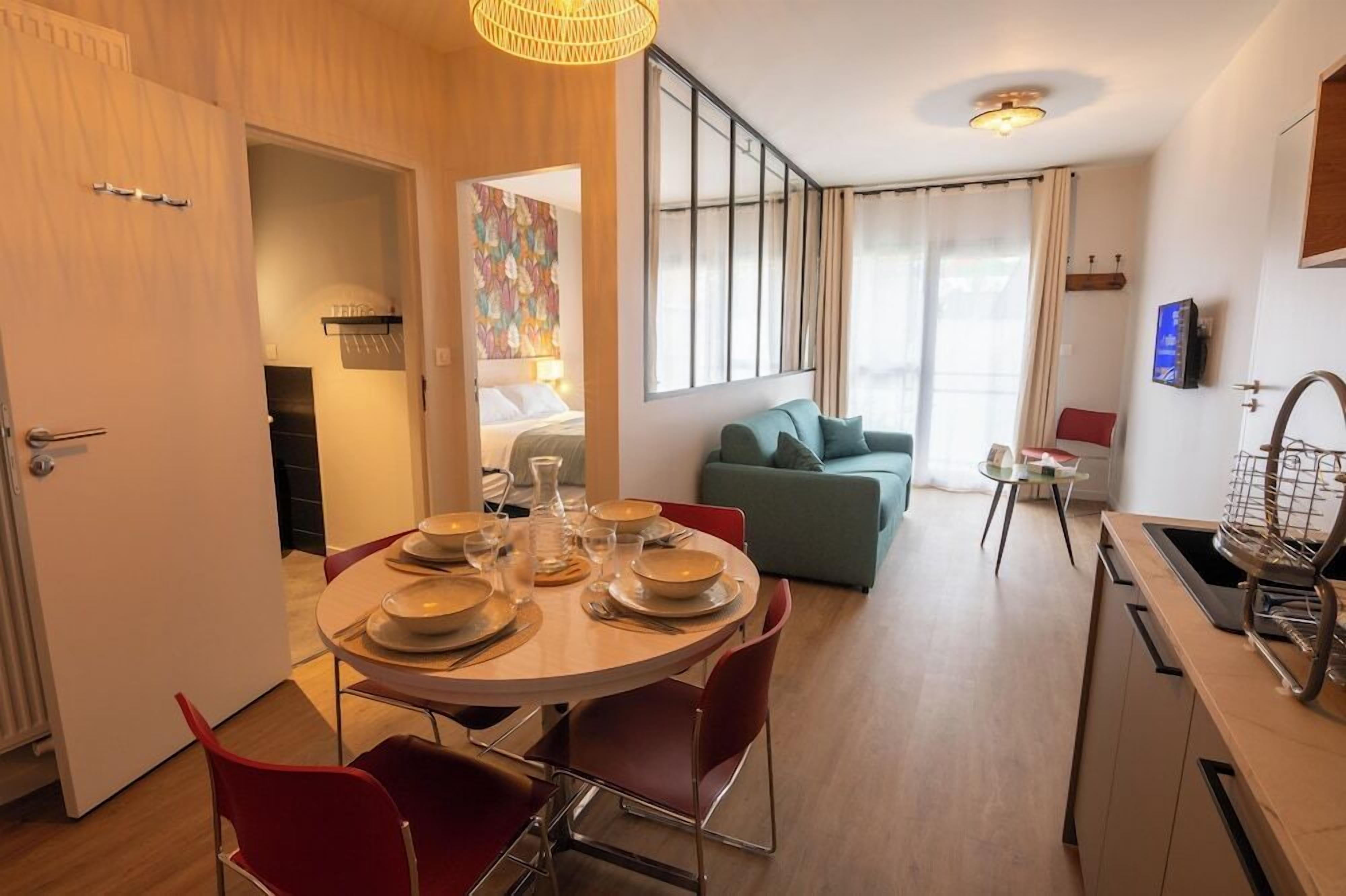 Une chambre d’hôtel moderne dotée d’un coin repas, d’un canapé et d’une kitchenette.