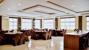 A spacious conference room with multiple tables and chairs, large windows, and a polished floor. - Portola Grand Renggali Hotel (Takengon)