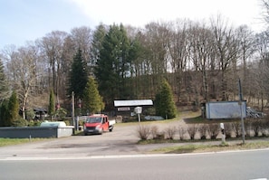 A red truck parked at a gated entrance with a building in the background. - Hotel Radevormwald (Radevormwald)