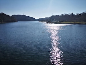 A calm lake with a clear reflection of the sky and distant hills. - Hotel Radevormwald (Radevormwald)
