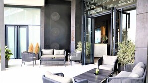 A modern outdoor seating area with sofas and chairs, a coffee table, and potted plants.