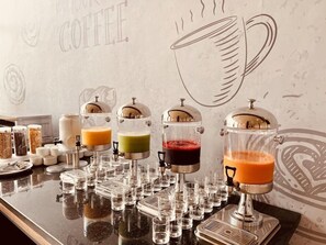 A coffee station with multiple dispensers and a wall with a coffee cup design. - Dominium Hotel (Agadir)