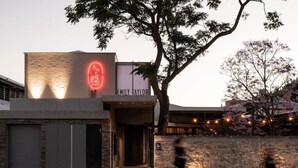 A building with a neon sign reading "EMILY TAYLOR" and a tree in front. - Garde Hotel (Perth)