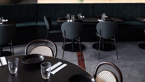 A restaurant with a mural of a wave and a person, modern furniture, and a staircase leading to an upper level. - Garde Hotel (Perth)