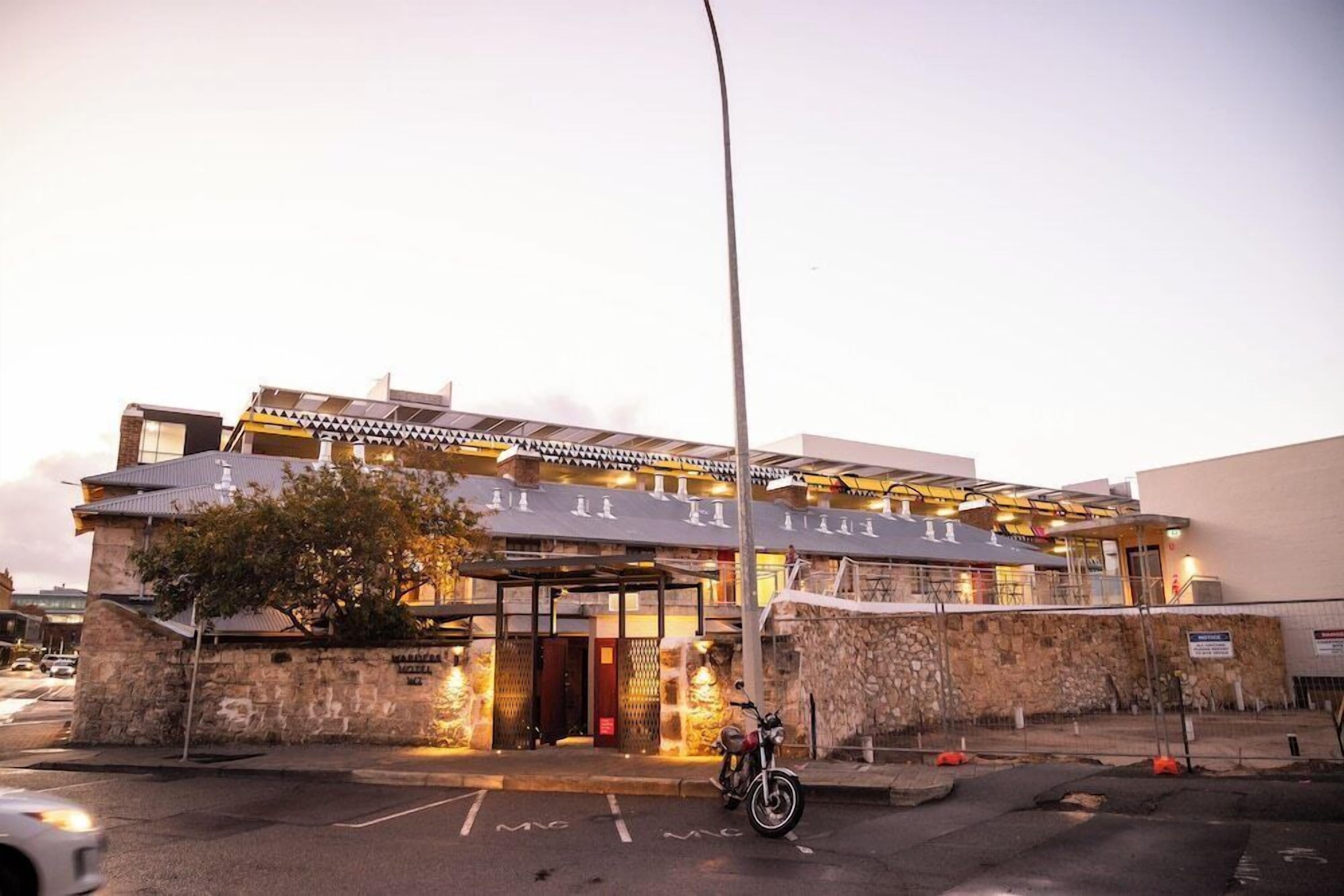 Un hotel de diseño moderno, con un acceso cubierto y fachada de piedra.