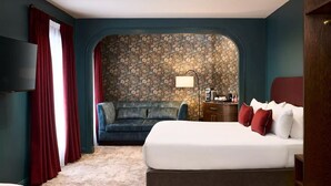 A hotel room with a large bed, a sofa, a TV, and a floral wallpaper. - The House Hotel Galway (Galway)
