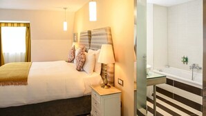 A hotel room with a bed, bedside lamp, and a glass-enclosed bathroom with a bathtub. - The House Hotel Galway (Galway)