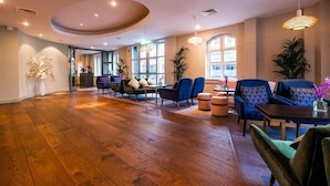 A spacious room with wooden flooring, a round ceiling feature, and a seating area with sofas and a table. - The House Hotel Galway (Galway)