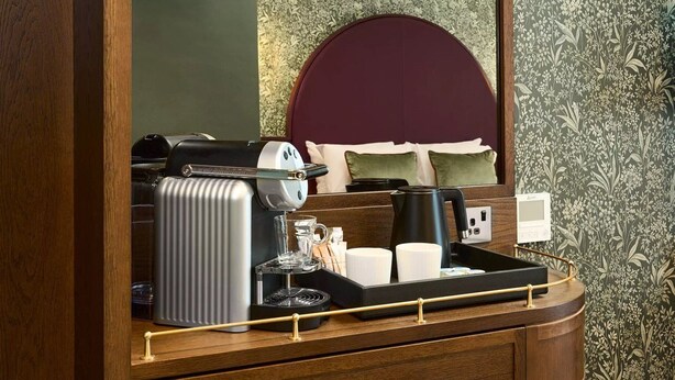A hotel room with a wooden desk, a coffee machine, a kettle, and a tray with cups and a glass. - The House Hotel Galway (Galway)