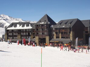 A large building with multiple balconies and a ski slope in front. - Residence Vacanceole Le Privilege (Germ)