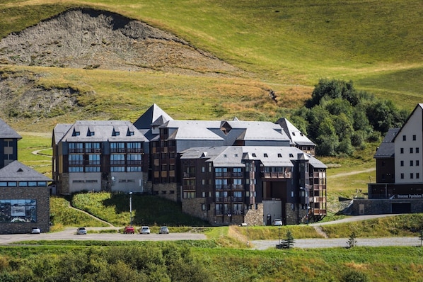 A multi-story building with a modern architectural design, featuring a mix of stone and wood materials, and a sloped roof.