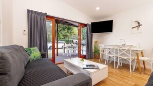 Ein modernes Wohnzimmer mit Sofa, Couchtisch und Essbereich mit Stühlen und Tisch.