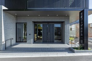 A modern hotel entrance with a glass door, a metal staircase, and a signboard. - Kyoto Plaza Hotel Kintetsu Jujo (Kyoto)