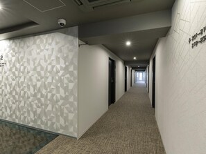 A hallway with geometric patterned walls, a number '2' sign, and a carpeted floor. - Kyoto Plaza Hotel Kintetsu Jujo (Kyoto)