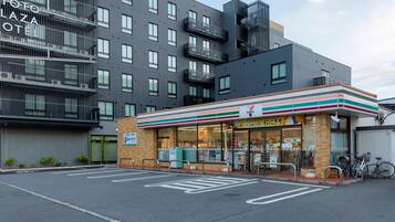 A 7-Eleven convenience store adjacent to a multi-story building with balconies.