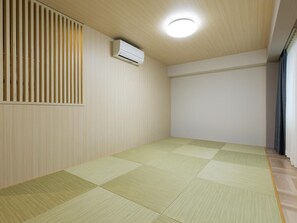 A room with a tatami mat floor, a ceiling fan, and a wall-mounted air conditioning unit. - Kyoto Plaza Hotel Kintetsu Jujo (Kyoto)