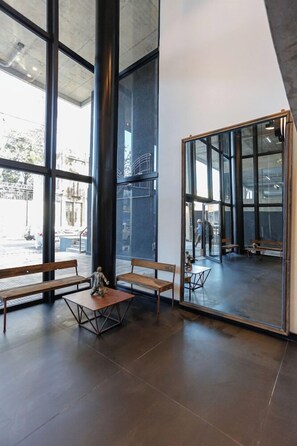 Un intérieur moderne avec de grandes fenêtres, des bancs en bois et une cloison en verre.