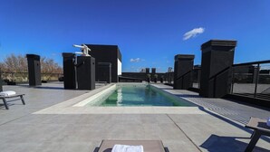 A rooftop pool area with lounge chairs and a statue. - Howard Johnson by Wyndham Buenos Aires La Boca Undici (Buenos Aires)