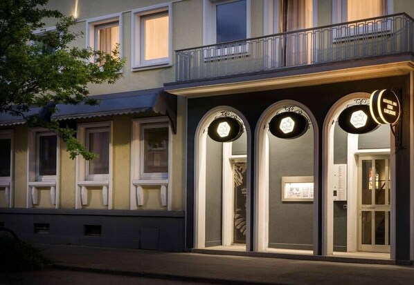 A building with a balcony, three arched windows, and a sign above the entrance. - ANA Living Karlsruhe, Trademark Collection by Wyndham (Karlsruhe)