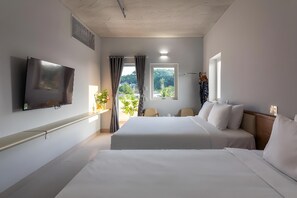 A hotel room with two beds, a TV, a window with a view, and a plant. - The Up Phu Quoc (Phu Quoc)
