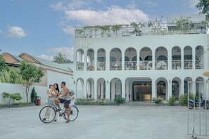A building with a white facade, multiple arches, and a balcony with plants. - The Up Phu Quoc (Phu Quoc)