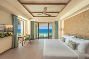A hotel room with a large bed, a desk, and a view of the ocean. - Fusion Resort and Villas Da Nang (Da Nang)