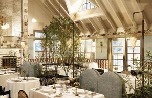 A restaurant with round tables, chairs, and hanging plants. - Baron's Cove (Sag Harbor)