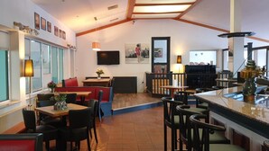 A restaurant with high tables, booths, and a bar area. - Sporthotel Papenburg (Papenburg)