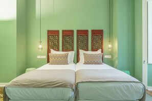 Una cama doble con cabecera de madera y dos lámparas fijadas a la pared.