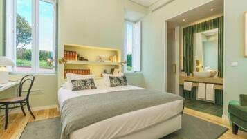 A bedroom with a bed, bedside tables, a desk, and a window.