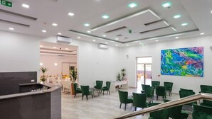 A modern lobby with a reception desk, green seating area, and a colorful abstract painting on the wall. - D-elegant Lapad Dubrovnik (Dubrovnik)