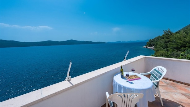 A balcony with a table and chairs overlooking a body of water and distant mountains. - D-elegant Lapad Dubrovnik (Dubrovnik)