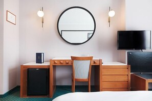 A hotel room with a round mirror, a desk with a chair, a television, and a small refrigerator. - Hotel Z Palace and Congress Center (Xanthi)