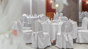 A banquet hall with round tables set for events, white chairs, and a modern ceiling design. - Hotel Z Palace and Congress Center (Xanthi)