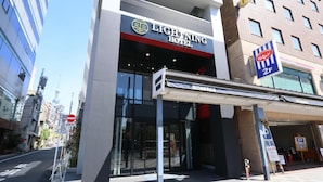 The exterior of the Lightning Hotel with a clear entrance, a parking sign, and a view of the surrounding urban area. - Lightning Hotel (Tokyo)