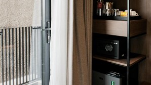 Ein Hotelzimmer mit einer Schiebetür, einer Minibar und einem kleinen Safe.