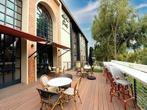 An outdoor patio with wicker furniture and a brick building with large windows. - Hotel Perte Montecasino (Johannesburg)
