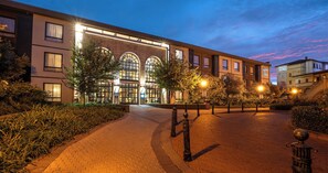 A hotel with a brick facade, large arched windows, and a paved walkway. - Hotel Perte Montecasino (Johannesburg)